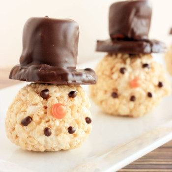 Snowmen Rice Krispie Treats. Rice Krispie Treats made into balls for snowmen heads. Top hats are made from shortbread cookies and large marshmallows covered in dark chocolate.