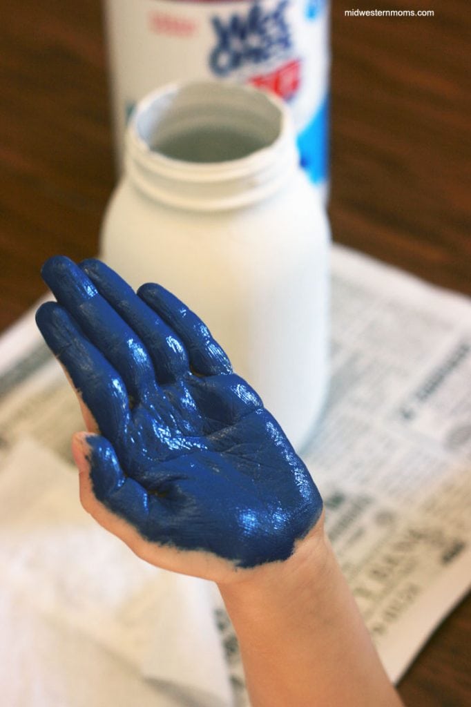 Paint Hand with paint to put handprint on jar