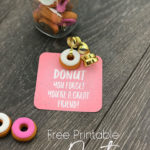 Printed Donut Valentine Card with a donut eraser attached with gold ribbon. Sitting next to a jar of donut erasers.