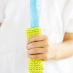Child holding a Popsicle that has a crocheted popsicle koozie around it. Helps to keep hands from freezing while eating popsicles.