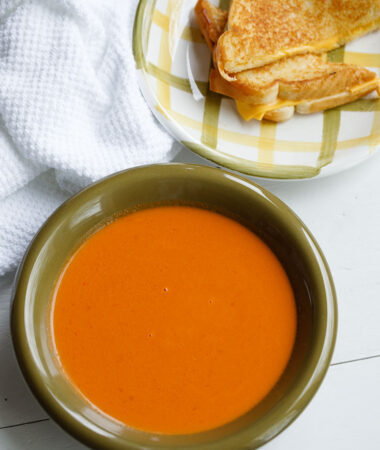 Bowl of homemade tomato soup with a grilled cheese sandwich