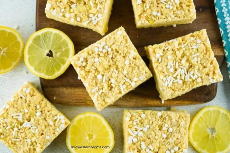 Lemon Rice Krispie Treats squares laying on  a cutting board.