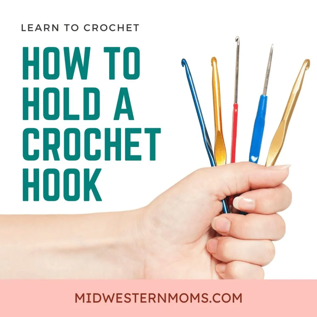 Hand holding crochet hooks